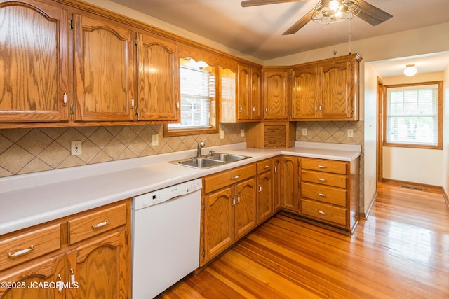 7515 Rte M, Jefferson City, MO 65101 - kitchen featuring dishwasher, a sink, light wood-type flooring, and brown cabinets
