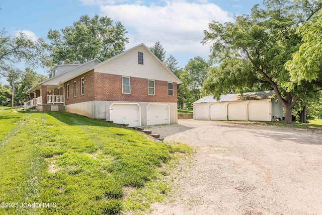 7515 Rte M, Jefferson City, MO 65101 - view of side of home featuring brick siding, gravel driveway, a lawn, and covered porch