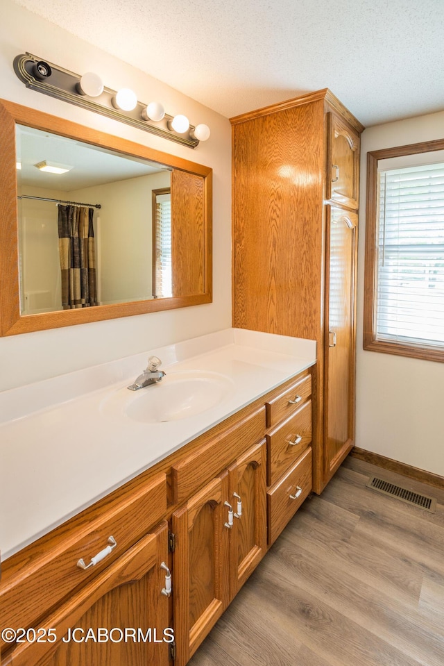 7515 Rte M, Jefferson City, MO 65101 - full bath with vanity, wood finished floors, a shower with shower curtain, a textured ceiling, and baseboards