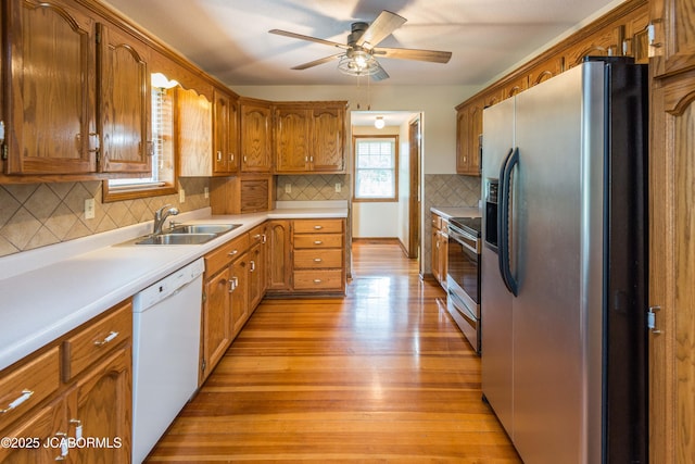7515 Rte M, Jefferson City, MO 65101 - kitchen featuring appliances with stainless steel finishes, a sink, ceiling fan, light wood-type flooring, and brown cabinetry