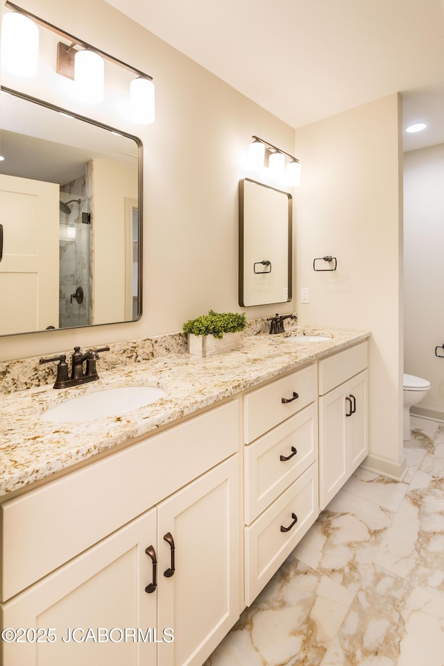 full bathroom featuring a stall shower, marble finish floor, a sink, and double vanity