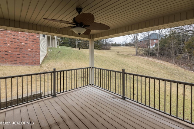 wooden terrace with a lawn and a ceiling fan