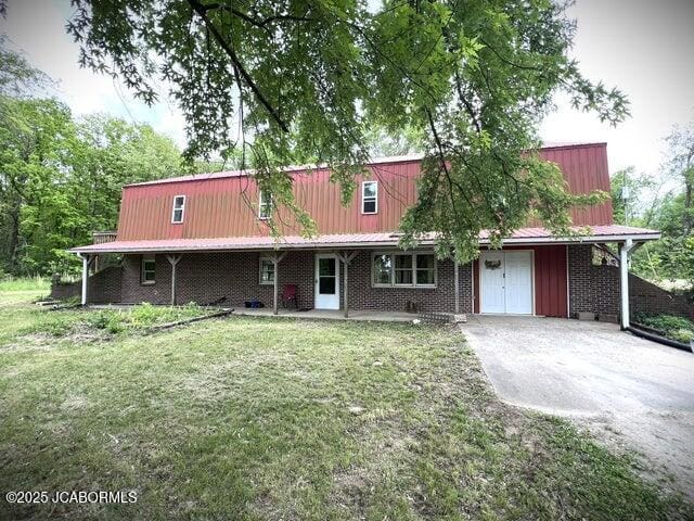 view of front facade featuring a front yard and metal roof