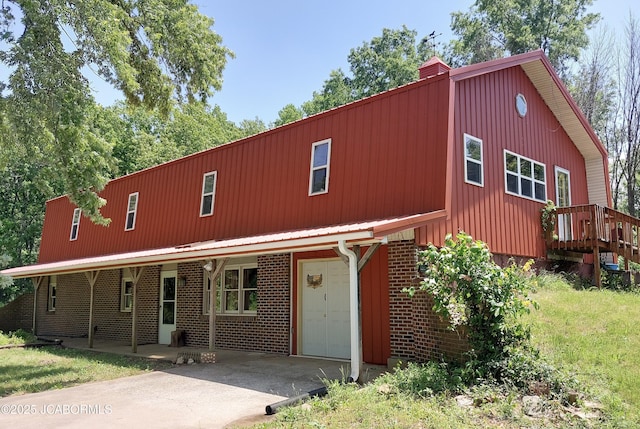 5888 State Rd E, Auxvasse, MO 65231 - view of front of property featuring a chimney, a metal roof, driveway, and brick siding