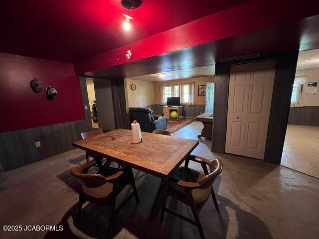 dining area with a wainscoted wall and wood walls