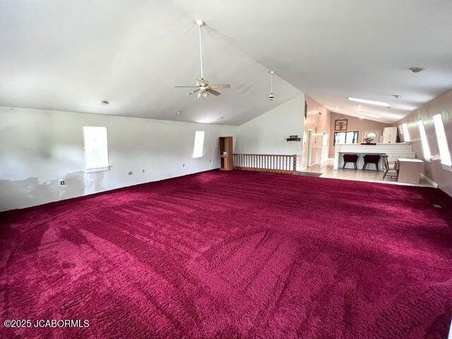 additional living space with vaulted ceiling, carpet, a ceiling fan, and healthy amount of natural light