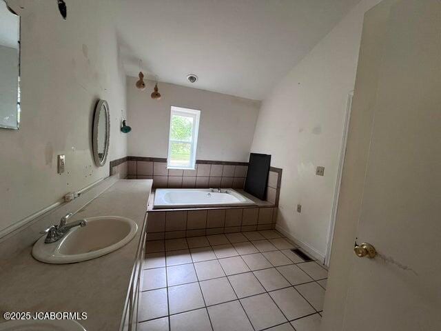 full bath with a bath, vanity, and tile patterned flooring