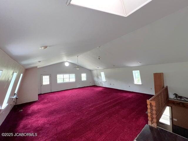 additional living space with vaulted ceiling, carpet floors, healthy amount of natural light, and a ceiling fan