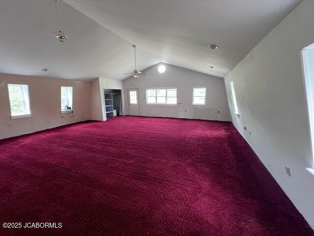 additional living space featuring vaulted ceiling, plenty of natural light, a ceiling fan, and carpet flooring