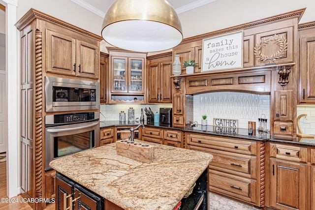 kitchen featuring tasteful backsplash, dark stone countertops, a center island with sink, and appliances with stainless steel finishes