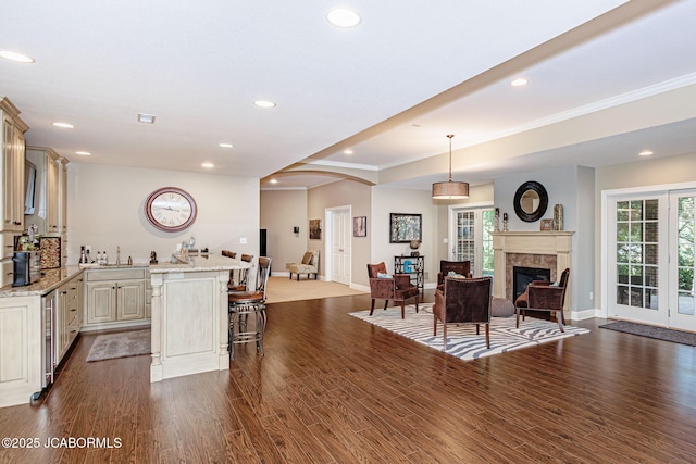 kitchen with open floor plan, a healthy amount of sunlight, a kitchen bar, and dark wood-style floors