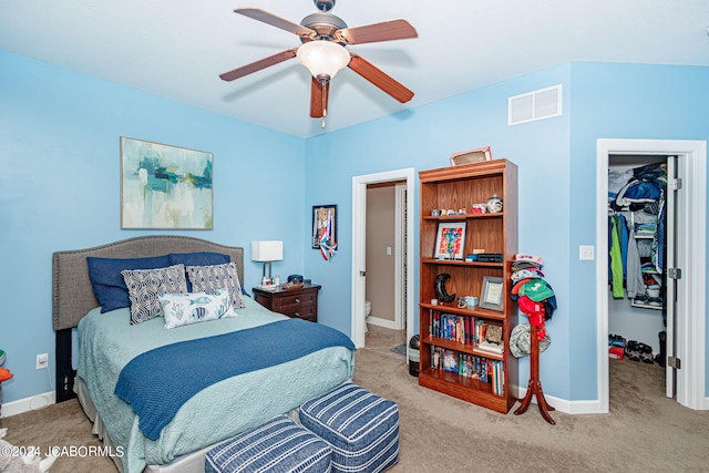 carpeted bedroom featuring ceiling fan, a walk in closet, and a closet