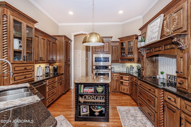 kitchen featuring pendant lighting, backsplash, dark stone countertops, and stainless steel appliances