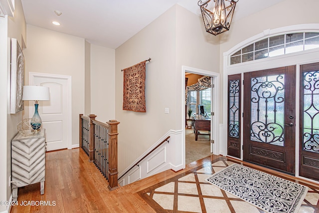 entryway with hardwood / wood-style floors and a chandelier