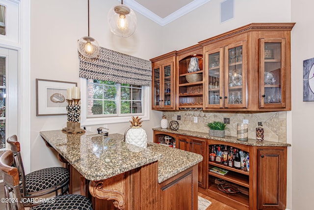 bar with decorative backsplash, pendant lighting, light stone counters, and crown molding