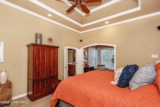 bedroom featuring light carpet, connected bathroom, ceiling fan, and crown molding