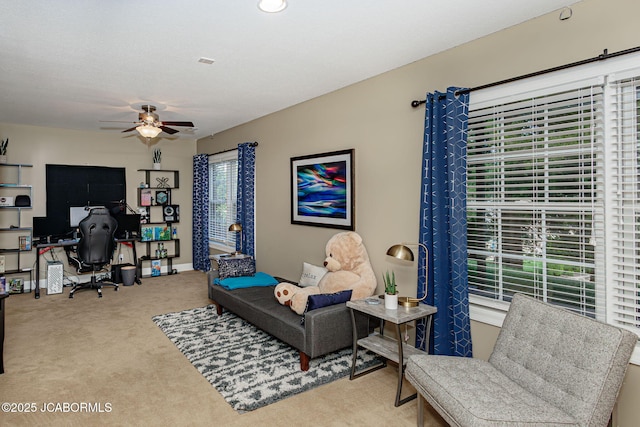 carpeted living room with ceiling fan