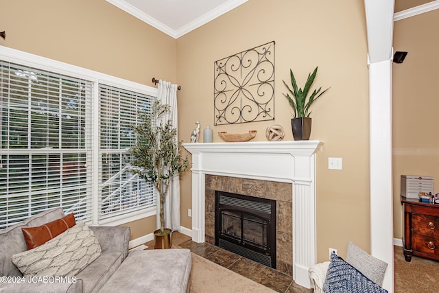 living area with a tiled fireplace and crown molding