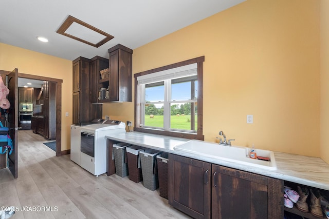8596 County Rd 146, Williamsburg, MO 63388 - clothes washing area with washing machine and dryer, recessed lighting, cabinet space, a sink, and light wood-style flooring