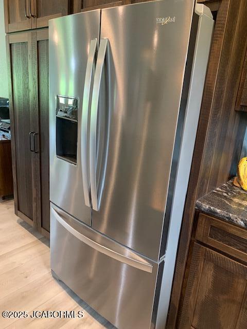 8596 County Rd 146, Williamsburg, MO 63388 - interior details with dark stone counters, stainless steel refrigerator with ice dispenser, dark brown cabinetry, and light wood-type flooring