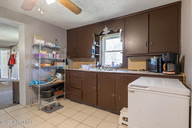 97 Stoddard Rd, Olean, MO 65064 - kitchen with fridge, a textured ceiling, dark brown cabinetry, ceiling fan, and light tile patterned floors