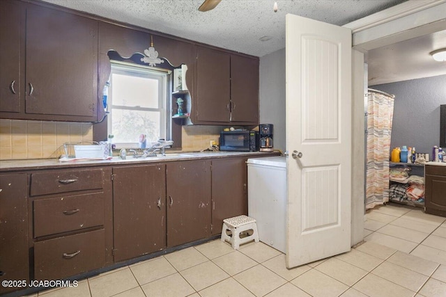 97 Stoddard Rd, Olean, MO 65064 - kitchen with black microwave, dark brown cabinetry, light tile patterned floors, a textured ceiling, and light countertops