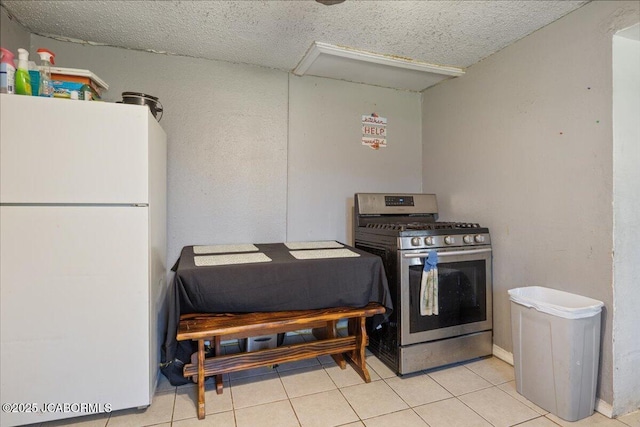 97 Stoddard Rd, Olean, MO 65064 - kitchen with freestanding refrigerator, stainless steel gas range, tile patterned flooring, and a textured ceiling