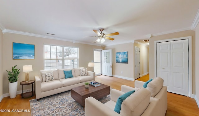 living area with crown molding, visible vents, a ceiling fan, light wood-type flooring, and baseboards