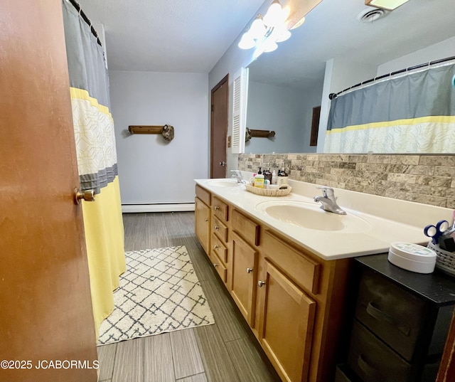 501 W Morgan St, Tipton, MO 65081 - full bathroom featuring a baseboard heating unit, double vanity, and wood finished floors
