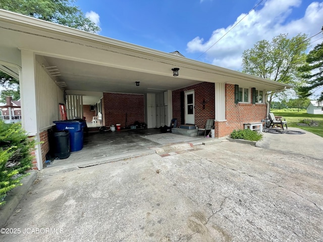 501 W Morgan St, Tipton, MO 65081 - view of side of property with brick siding, a carport, and driveway