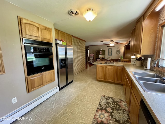 501 W Morgan St, Tipton, MO 65081 - kitchen featuring appliances with stainless steel finishes, baseboard heating, a peninsula, a ceiling fan, and light countertops