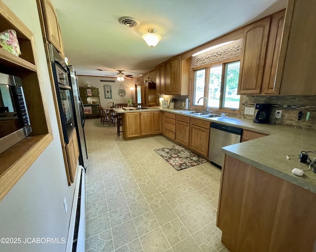 501 W Morgan St, Tipton, MO 65081 - kitchen featuring stainless steel dishwasher, a peninsula, backsplash, and light flooring