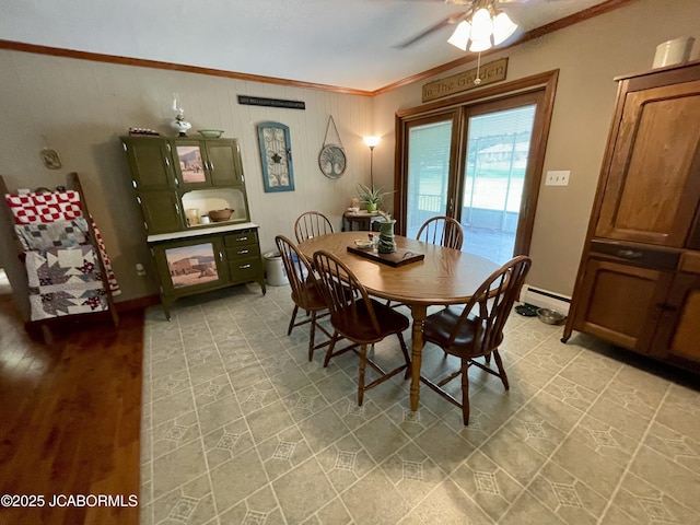 501 W Morgan St, Tipton, MO 65081 - dining room with crown molding, ceiling fan, a baseboard radiator, and wood walls