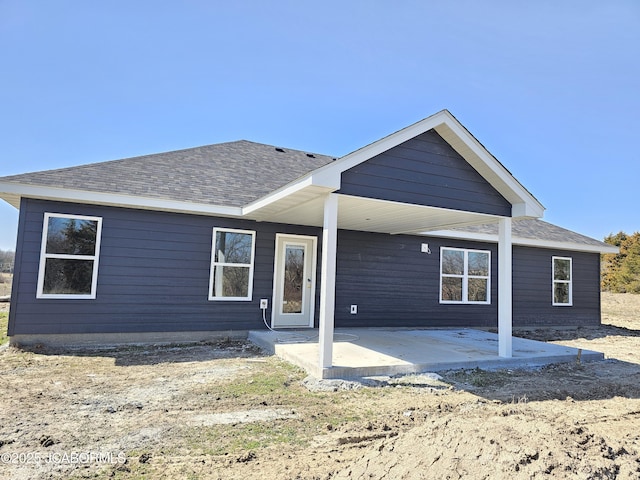 back of house featuring a patio area and a shingled roof