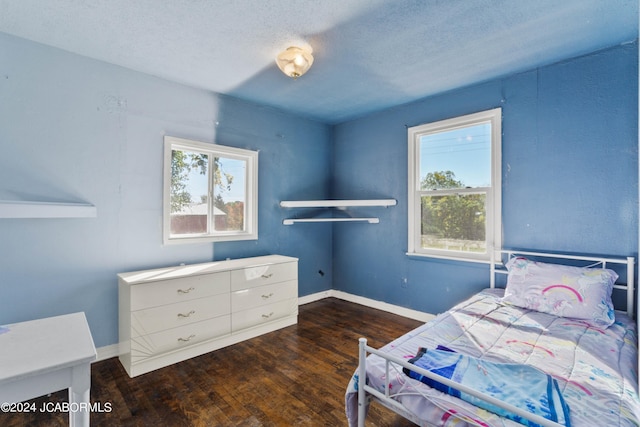 bedroom with a textured ceiling and dark hardwood / wood-style floors