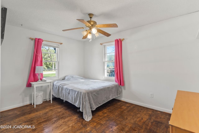 bedroom featuring a textured ceiling, ceiling fan, and dark hardwood / wood-style floors