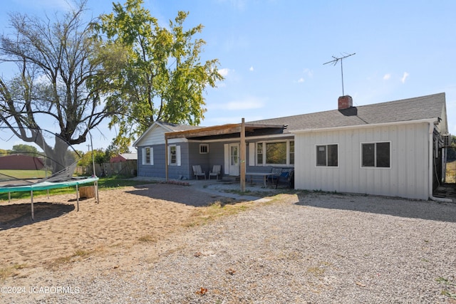 back of property featuring a patio and a trampoline