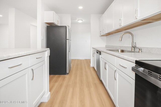 1214 Lynn St, Fulton, MO 65251 - kitchen with appliances with stainless steel finishes, light wood-style flooring, white cabinetry, light countertops, and recessed lighting