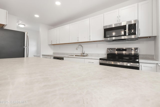 1214 Lynn St, Fulton, MO 65251 - kitchen featuring appliances with stainless steel finishes, light countertops, white cabinets, and recessed lighting