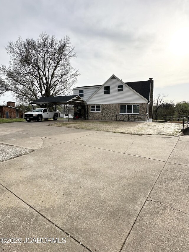 1434 Sunset Lake Rd, Jefferson City, MO 65109 - view of front of home featuring stone siding, an attached carport, and concrete driveway