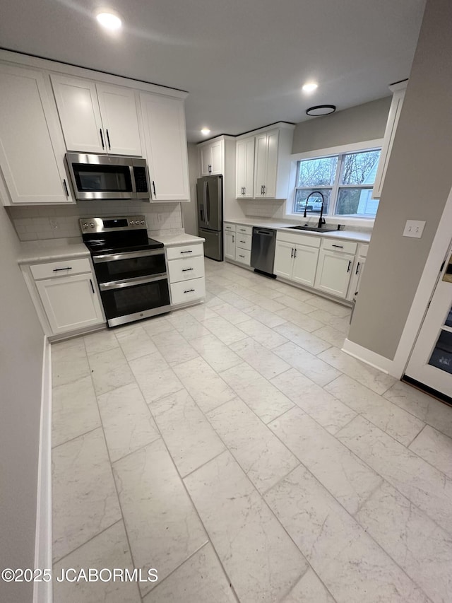 1434 Sunset Lake Rd, Jefferson City, MO 65109 - kitchen featuring light countertops, decorative backsplash, marble finish floor, a sink, and appliances with stainless steel finishes