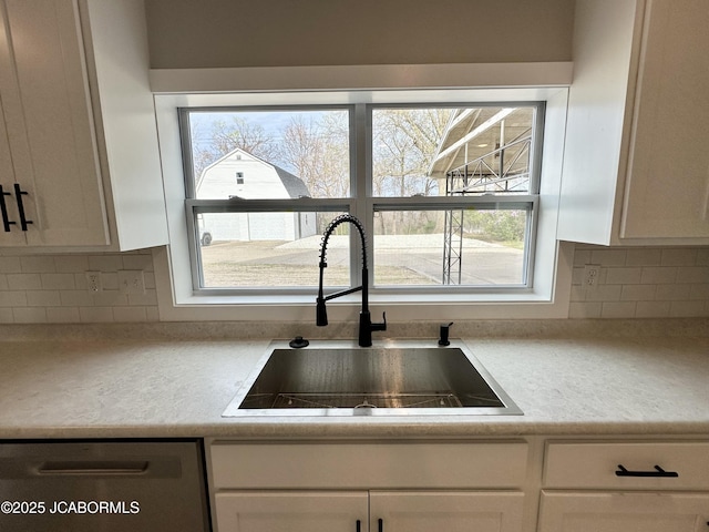 1434 Sunset Lake Rd, Jefferson City, MO 65109 - kitchen featuring white cabinets, a sink, backsplash, and light countertops