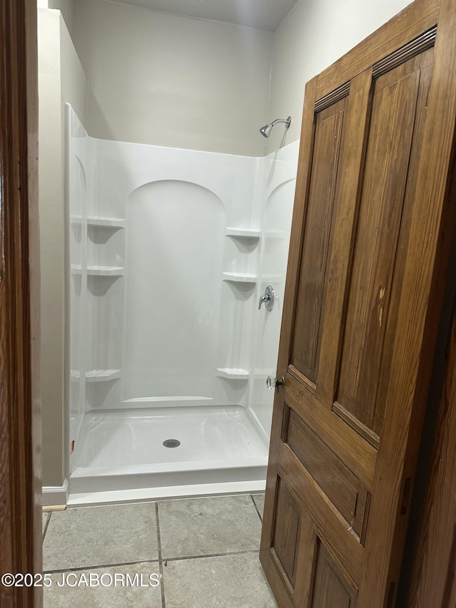 bathroom with tile patterned flooring and walk in shower