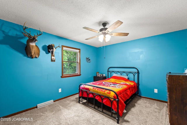 4300 W E Ridge Rd, Columbia, MO 65202 - carpeted bedroom featuring baseboards, a textured ceiling, and ceiling fan