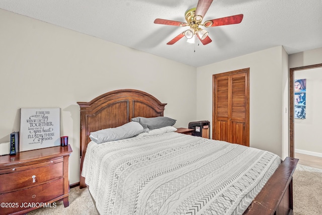 4300 W E Ridge Rd, Columbia, MO 65202 - bedroom with a closet, light carpet, ceiling fan, a textured ceiling, and baseboards