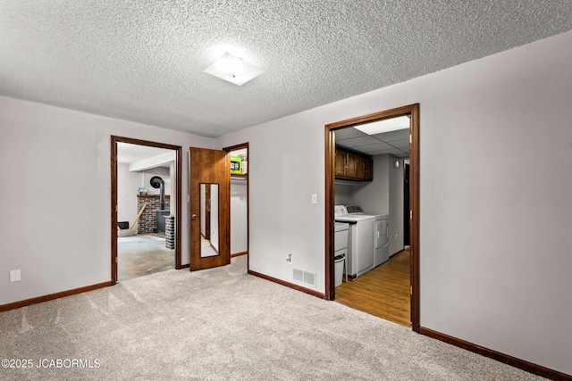 4300 W E Ridge Rd, Columbia, MO 65202 - carpeted empty room with washing machine and clothes dryer, baseboards, and a textured ceiling
