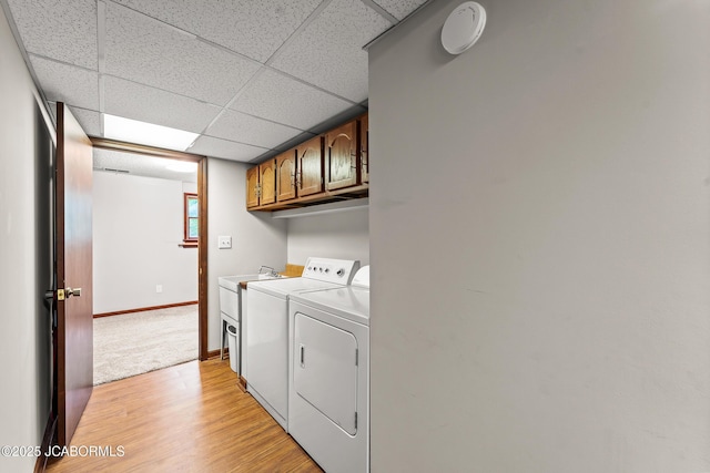 4300 W E Ridge Rd, Columbia, MO 65202 - laundry area with separate washer and dryer, cabinet space, light wood-style floors, and baseboards