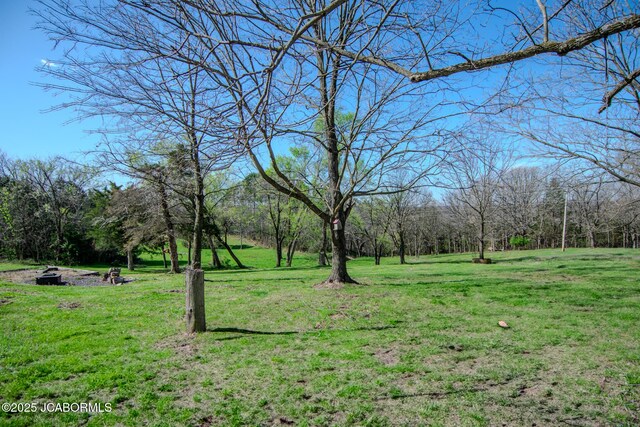 12271 County Road 4037, Holts Summit, MO 65043 - view of grassy yard featuring an outdoor fire pit