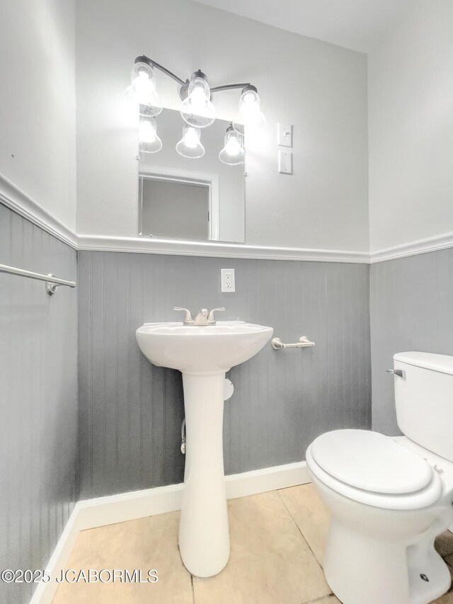 12271 County Road 4037, Holts Summit, MO 65043 - half bathroom with wainscoting, toilet, tile patterned flooring, baseboards, and a sink