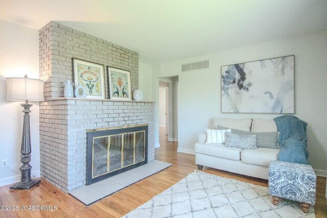 12271 County Road 4037, Holts Summit, MO 65043 - living area featuring wood finished floors, baseboards, and a brick fireplace